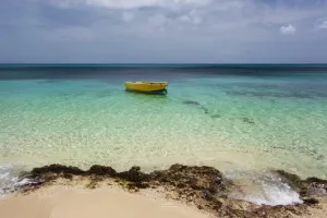 A lone boat in the turquoise water off a tropical island Frederiksted St Croix Virgin Islands United States of America Poster Print by Jenna Szerlag Design Pics (17 x 11)